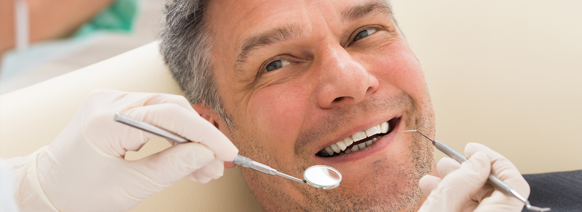 A man getting dental work done with a dentist working on his teeth.