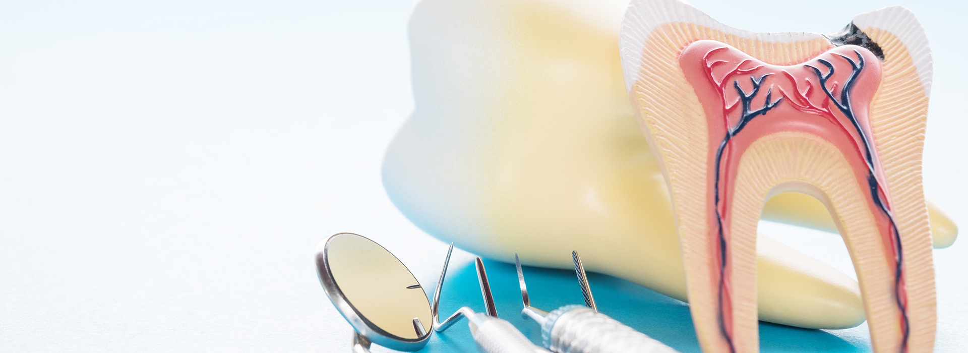 The image shows a pair of yellow teeth with a toothbrush placed next to them, both set against a white background.