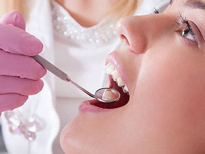 A person receiving dental treatment with a dentist performing the procedure.